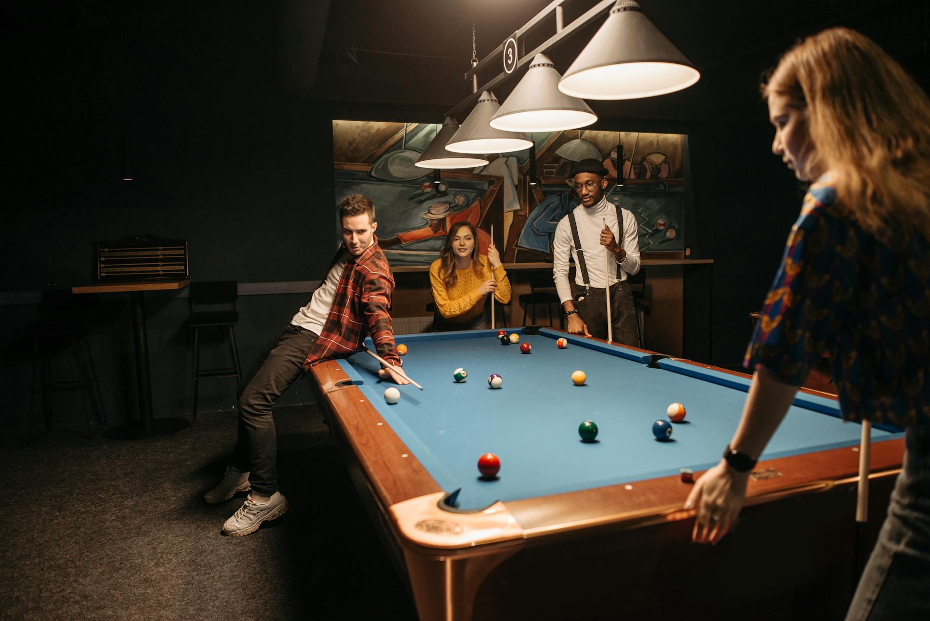 Grupa znajomych gra w bilard w przytulnym klubie w Mielcu
