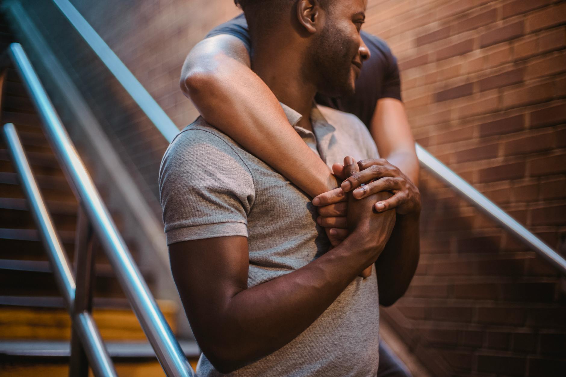Dwaj mężczyźni obejmują się czule na klatce schodowej